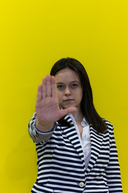 Vertical closeup of a woman extending her hand with a serious stop gesture