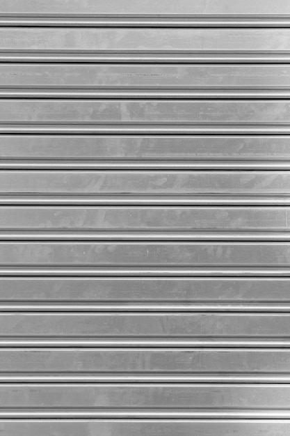 Vertical composition of a gray metal curtain protecting a closed shop or house