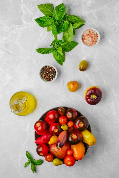 Photo vertical composition with assortment of tomatoes basil and spice