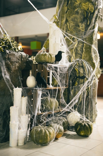 Vertical Halloween decorations indoors Pumpkins cobwebs and crows with candles photo area