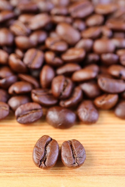 Vertical Image of Arabica VS Robusta Roasted Coffee Beans with Blurry Coffee Beans Pile in the Backdrop