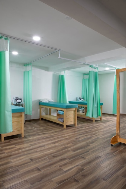 Vertical image of some stretchers with curtains in a rehabilitation clinic without people