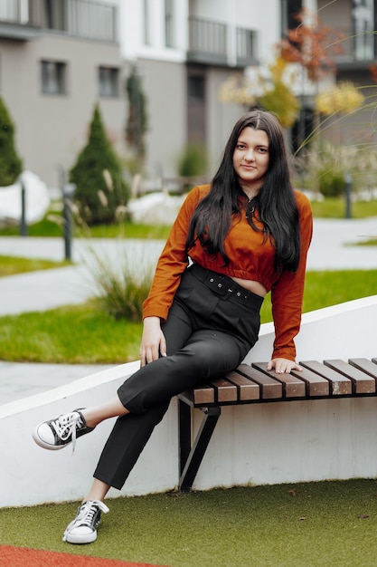 Vertical photo Beautiful carefree young teenage girl in casual clothes Portrait of a beautiful girl against the background of nature with a blurred background