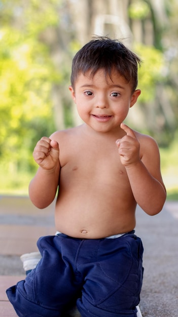 Vertical photo of portrait of a happy and smiling child with Down syndrome