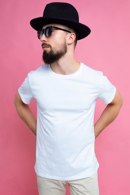 Vertical photo shot of confident brutal good looking young brunet bearded man wearing casual white