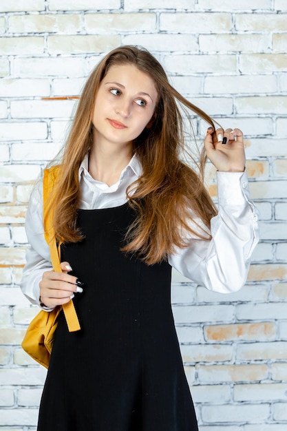 Vertical photo of young student stretching her hair and seems happy High quality photo