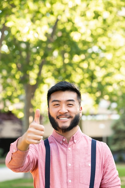 Vertical portrait of an asian man gesturing being well