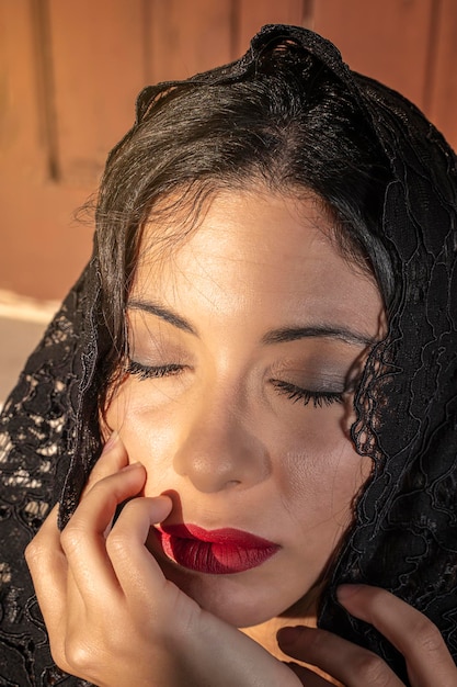 Vertical portrait of Come-hither Fashion young woman in black lace veil