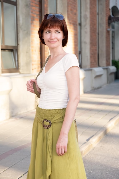 Vertical portrait of a woman in a long skirt with a bagbackpack