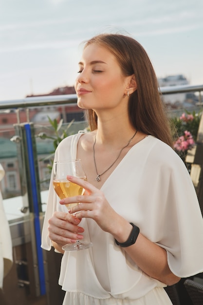 Vertical portrait of a woman smiling with her eyes closed, enjoying wine