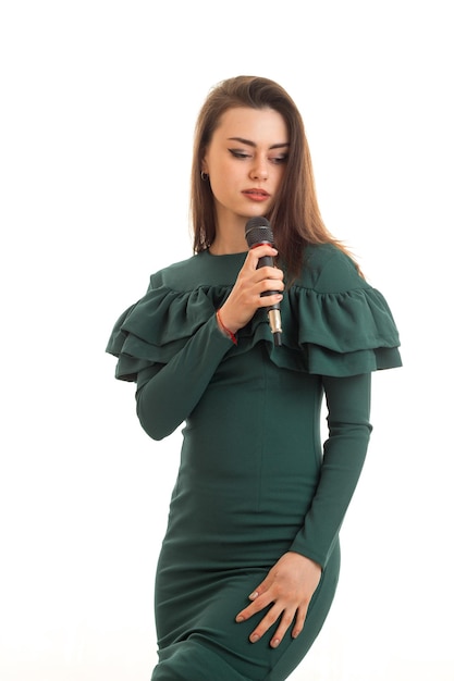 Vertical portrait of young beautiful girl with microphone isolated on white background