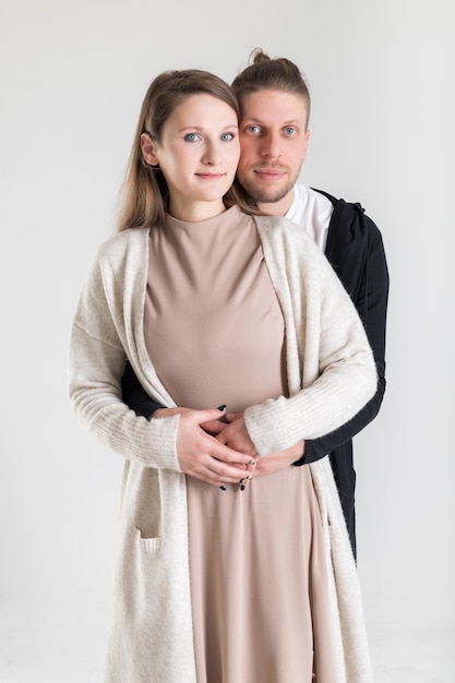 Vertical portrait of a young caucasian couple in love on a white background