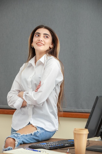 Vertical portrait of a young girl crossed her arms and laughing High quality photo