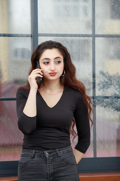 Vertical portrait of a young lady listening carefully phone talking High quality photo