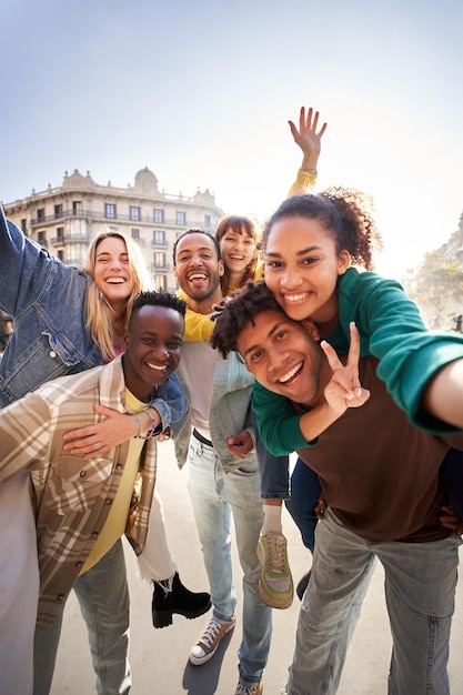 Vertical selfie of a group of cheerful students college friends travel through european cities