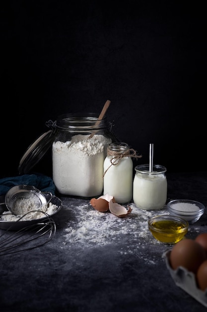 Vertical shot of the baking ingredients on the table against the blank black background