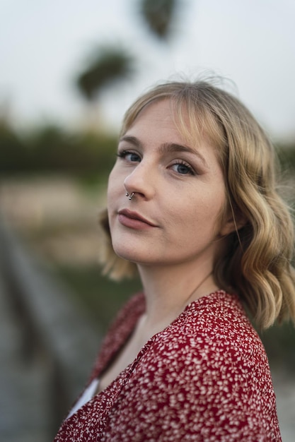 Vertical shot of a beautiful blonde Spanish Caucasian young woman posing in the park