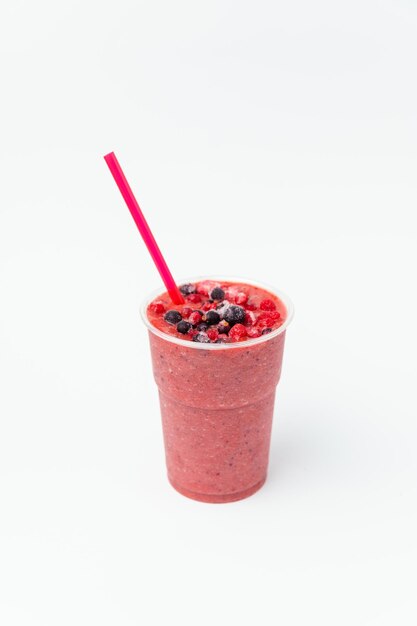 Photo vertical shot of a berry smoothie with frozen red and black currants on top