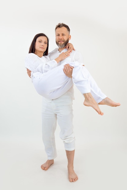 Vertical shot of couple man and woman look at camera healthy lifestyle male hold female in arms marr