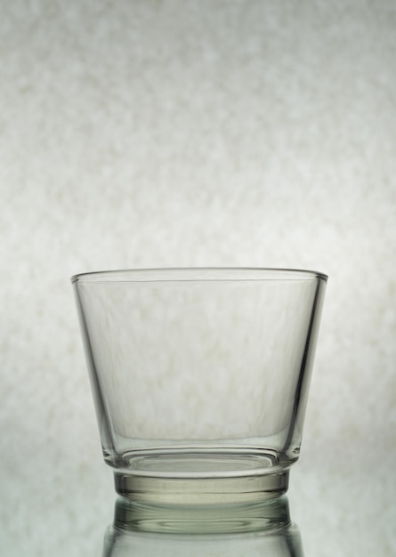 A vertical shot of an empty glass on a grey background