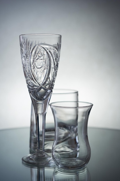 A vertical shot of empty glasses for different drinks on a grey background