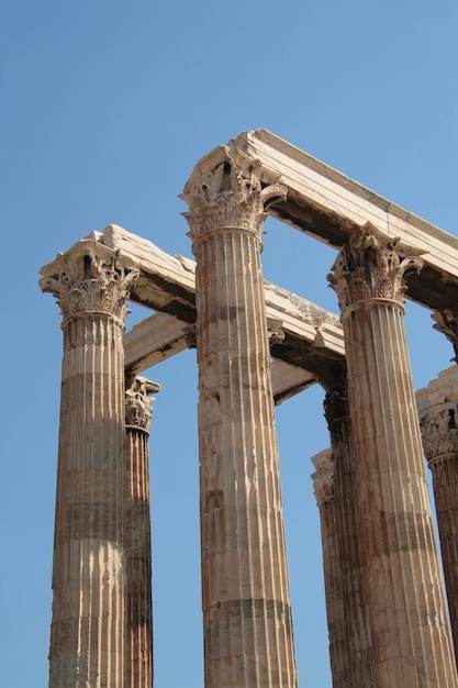 Vertical shot of the marble columns of Temple of Olympian Zeus in Greece against a blue sunny sky