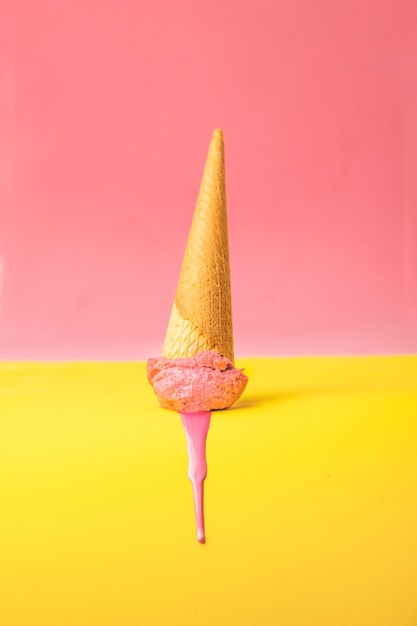 Vertical shot of melted pink ice cream on a colorful background