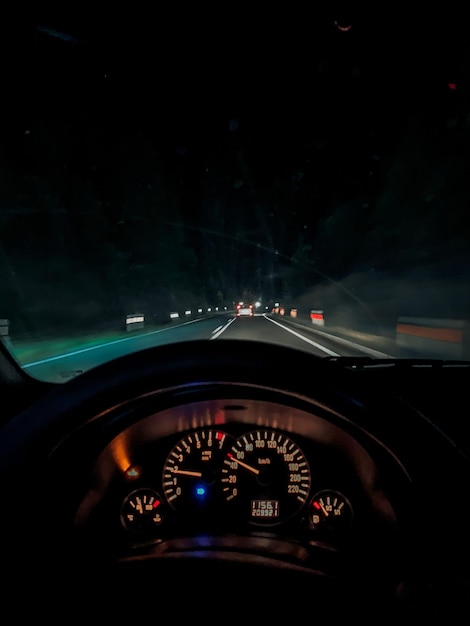 Vertical shot of the speedometer of a car driving on a highway at night