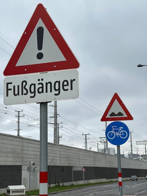 Vertical shot of a traffic sign on the road under gloomy grey sky