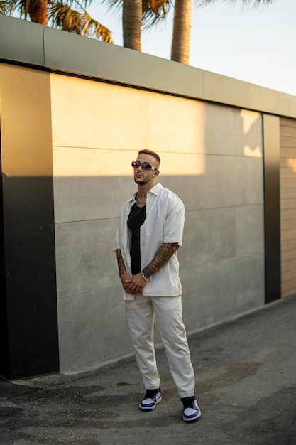 Vertical shot of a white Caucasian guy posing for a photoshoot outdoors