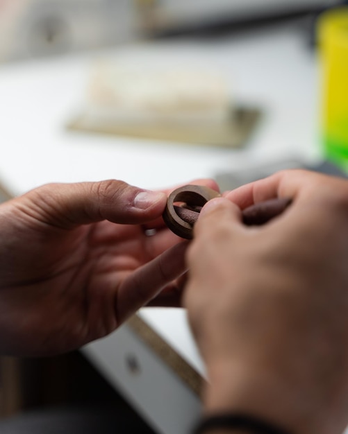 Vertical shot of a worker polishing a wooden ring