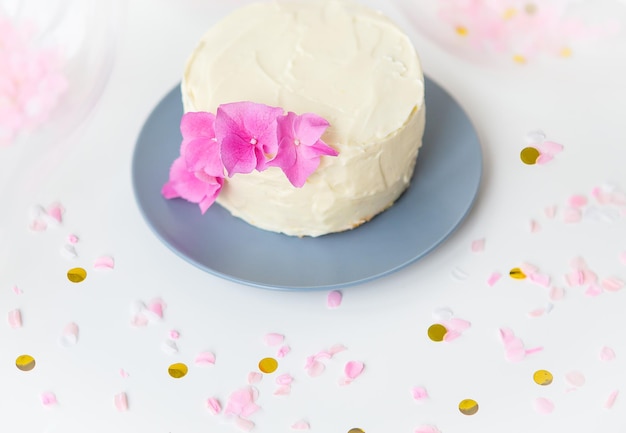 Very beautiful small white bento cake decorated with fresh flowers of pink hydrangeas Holiday and fun concept