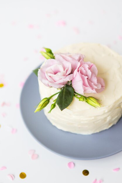 Very beautiful small white cake decorated with fresh eustoma flowers Holiday concept