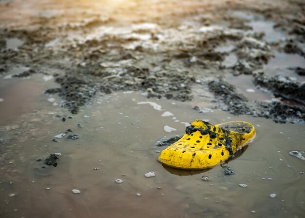 Very dirty yellow Shoe on the shore of a salt lake on a Sunny day