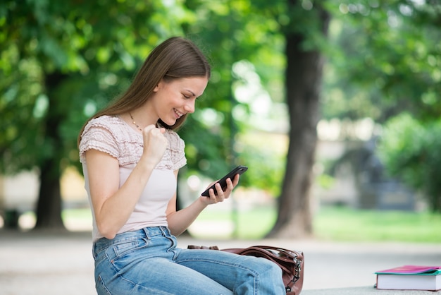 Very happy woman looking at her mobile phone