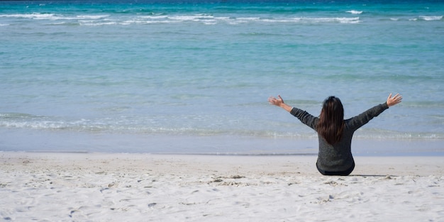 Very happy woman Sit on the sand, watch the beautiful sea view.