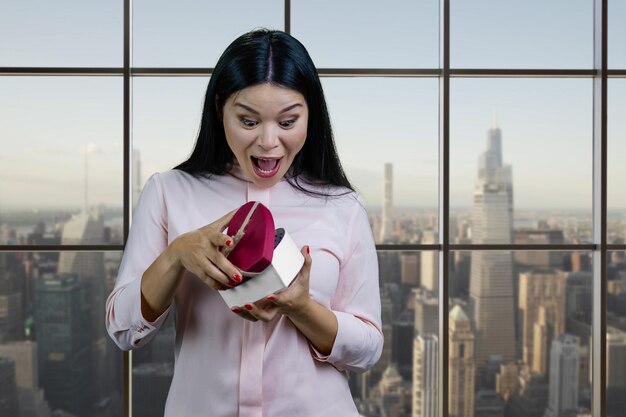 Very happy young asian woman is opening heart shape gift box