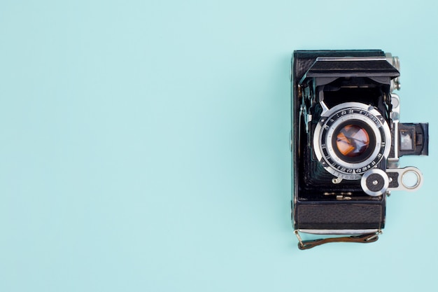 Very old camera on a gentle blue background. Top view.