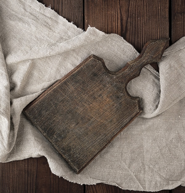 Very old empty brown wooden cutting board with handle