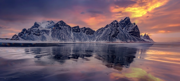 Vestrahorn mountaine on Stokksnes cape in Iceland during sunset with reflections. Amazing Iceland nature seascape. popular tourist attraction. Best famouse travel locations. Scenic Image of Iceland