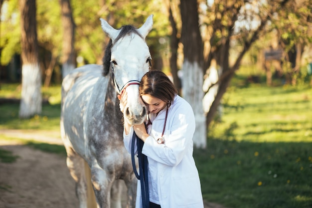 Vet enjoying with a horse outdoors at ranch.