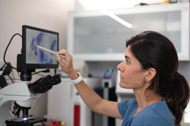 Veterinarian by touching the digital display of the microscope