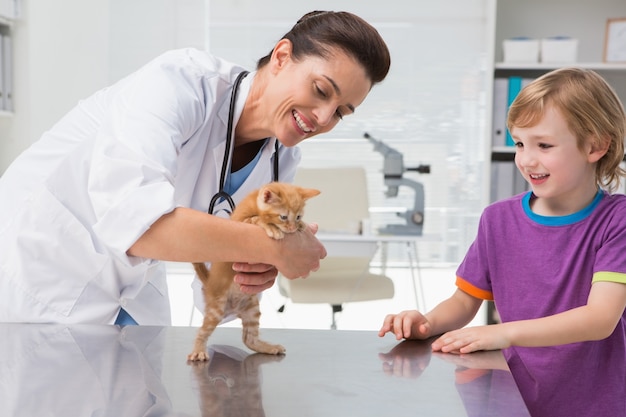 Veterinarian examining a cat with its owner 