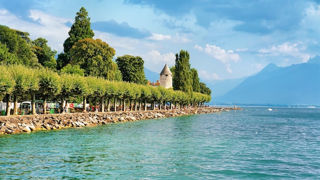 Vevey, Switzerland - August 27, 2016: Promenade with Alps mountains and Geneva Lake Riviera in Vevey, Vaud canton, Switzerland. People on the background