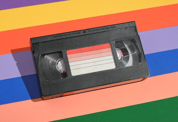 Vhs video cassette lies on colored striped background Retrostyle composition Bright creative inspiration