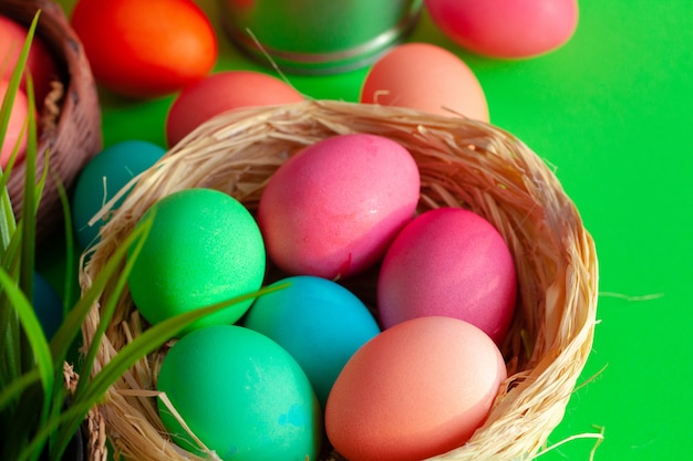 Vibrant colored eggs in a nest on green. Easter concept