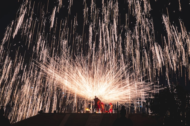 Vibrant fire show at night with numerous sparks