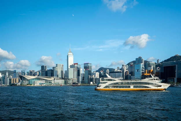 Photo vibrant hong kong skyline with ferry on a clear day