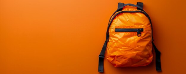 Photo vibrant orange backpack against bright orange background perfect for school travel hiking and