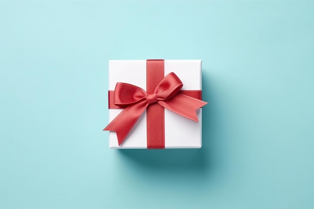 Vibrant red gift box decorated with white satin ribbon and bow against a pastel blue backdrop